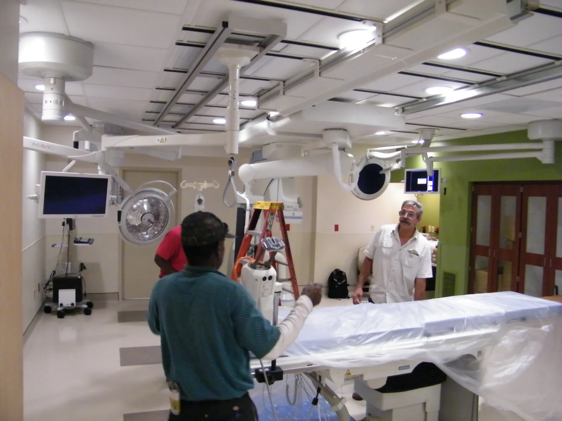 Hospital room with medical equipment and workers.