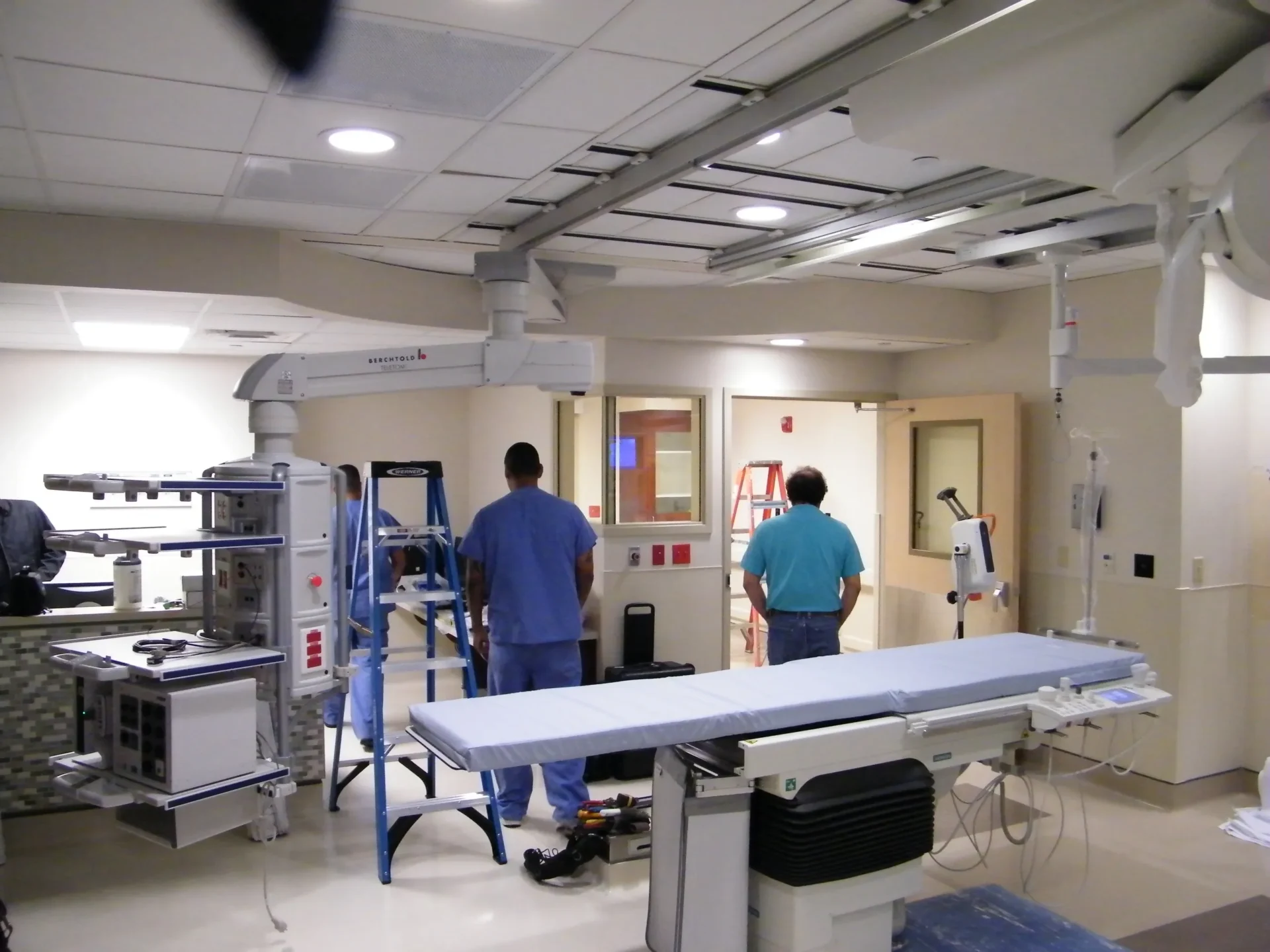 Hospital room with medical equipment and staff.